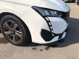 the front end of a white car with black rims parked in a parking lot
