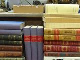 many books stacked on top of each other on a shelf