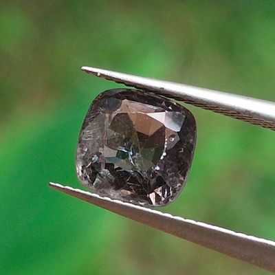 un gros plan d'un diamant noir tenu par une pince