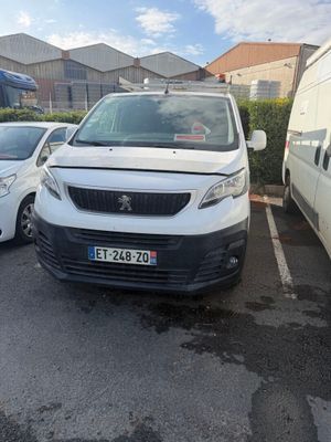 une camionnette blanche garée dans un parking à côté d'une camionnette blanche