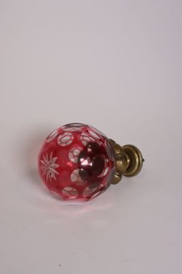 une boule en verre rouge ornée de fleurs blanches
