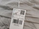 a label on the back of a shirt that is hanging on a hanger