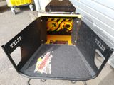 a black cart with a sign on it sitting in front of a garage