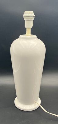 a white lamp that is on a table with a black background