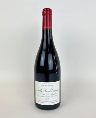 une bouteille de vin rouge posée sur une table blanche