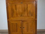 a wooden cabinet with a marble top in the corner of a room