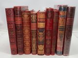 several old books lined up in a row on a white surface