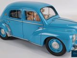 a blue toy car with a dog sitting in the passenger seat