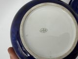 someone is holding a blue and white bowl with a white rim
