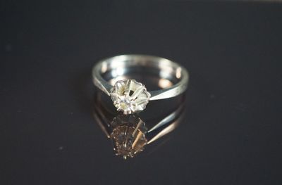 une photo d'une bague en diamant posée sur une surface noire