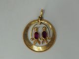 an image of a gold pendant with two birds on it