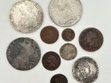 un assortiment de pièces de monnaie en argent et en argent sur une surface blanche