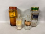 bottles of various sizes and colors are lined up on a table