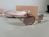 sunglasses and case on a table next to a pink velvet case