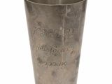 une tasse en métal portant une inscription sur un fond blanc