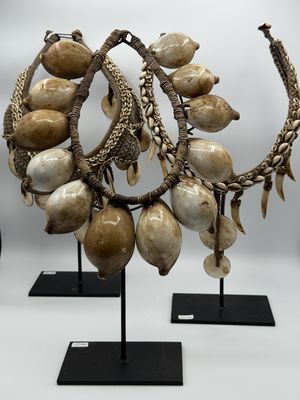 several pieces of jewelry are displayed on stands on a white surface