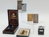 plusieurs types différents de briquets et d'étuis à briquets posés sur une table
