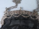 an image of a black purse with a chain around it