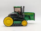 a green toy tractor with yellow wheels on a white background