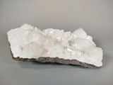 white crystals on a rock on a gray surface