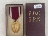 medal in a box on a white surface with a ribbon around it