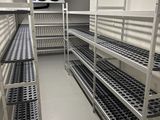 de nombreuses étagères au milieu d'une pièce, sur lesquelles sont disposés de nombreux objets