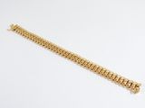 a gold bracelet on a white surface