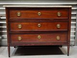 une commode en bois ornée de boutons en laiton