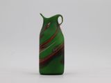 green glass vase with a red and black swirl on it