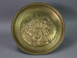 gold plate with a picture of a man riding a horse and a woman riding a horse