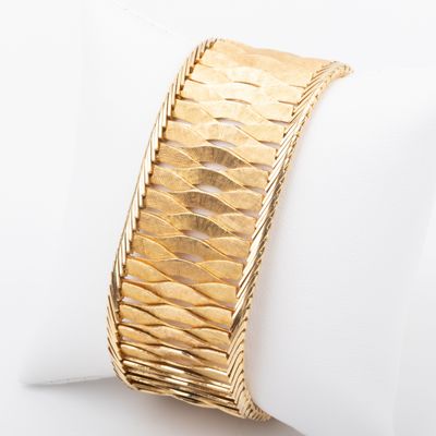 an image of a close up of a gold bracelet on a napkin