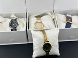 three watches in a white box on a black table