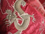 two pillows with a dragon design on them on a bed