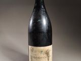 an old bottle of wine sitting on top of a table