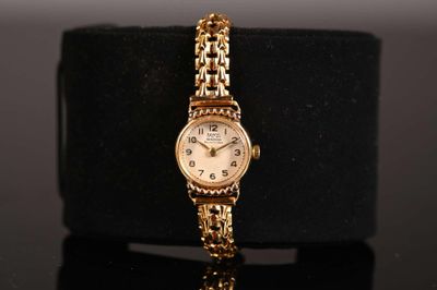 an image of a gold wrist watch with a chain around it