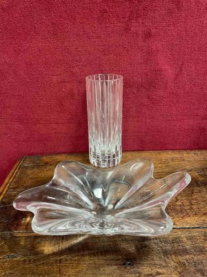 un vase en verre posé sur une table en bois, avec un mur rouge en arrière-plan