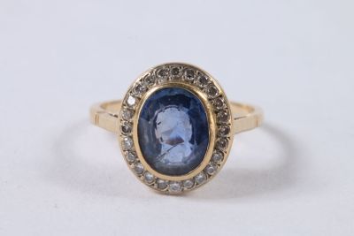 gros plan d'une bague avec une pierre bleue entourée de diamants