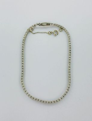 un bracelet en perles argentées muni d'un fermoir, sur fond blanc