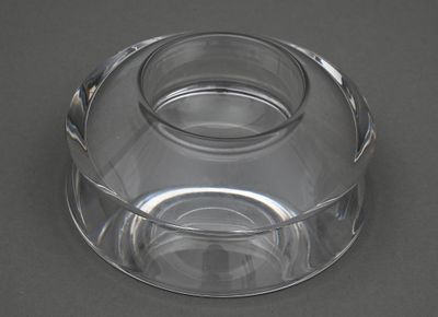un saladier en verre transparent muni d'un couvercle, posé sur une table