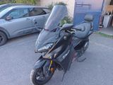 une moto noire garée sur un parking à côté d'une voiture