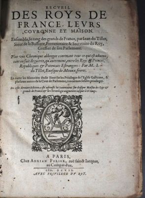 un vieux livre posé sur une table en bois à côté d'une fenêtre