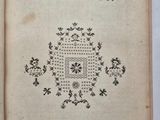 un vieux livre sur lequel est dessinée une croix, posé sur une table