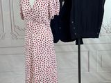 two women ' s dresses on a mannequin stand in front of a white wall