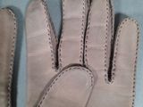 pair of leather gloves with stitching on them on a blue surface
