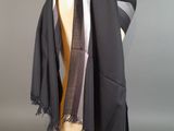 écharpe grise et noire sur une tête de mannequin, posée sur une tête de mannequin