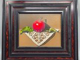 tableau représentant une pomme dans un panier en osier, sur laquelle repose une feuille