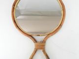 an image of a wooden hand mirror hanging on a wall