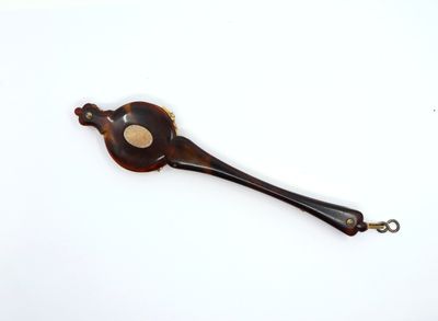 a small wooden spoon with a metal handle on a white surface