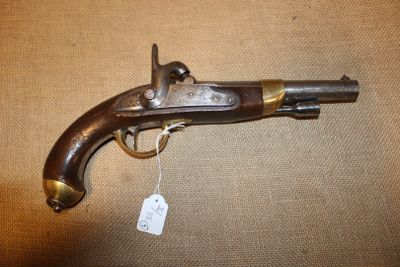 un vieux pistolet, muni d'une étiquette, posé sur une table