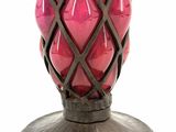 a pink vase that is on a stand on a white background